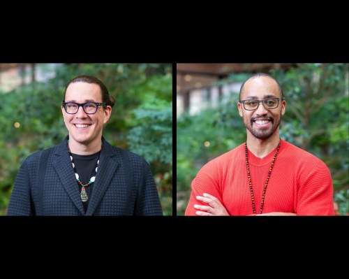 Two people smiling in front of a garden background. Both people are wearing necklaces; one is wearing a black blazer and the other a red sweater.