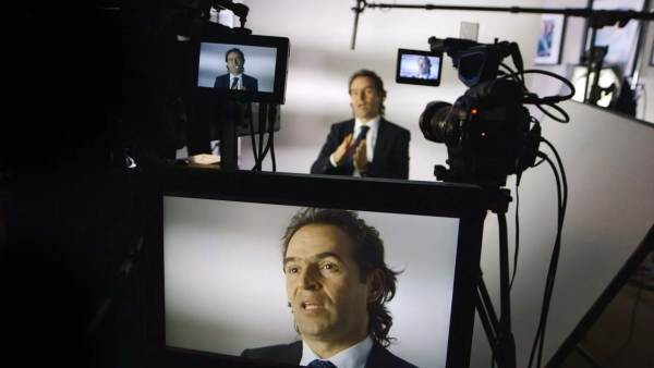 Federico Gutiérrez Zuluaga sitting on a film set in front of multiple cameras with his face displayed on all monitors.